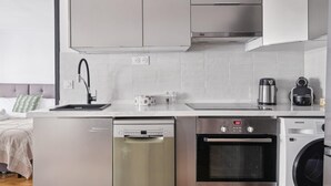 Een moderne keuken met roestvrijstalen apparatuur, waaronder een vaatwasser, oven en wasmachine.