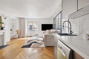 A modern kitchen with a dishwasher, a sink, and a large window. - Charming 1BR near Louvre & Tuileries (Paris)