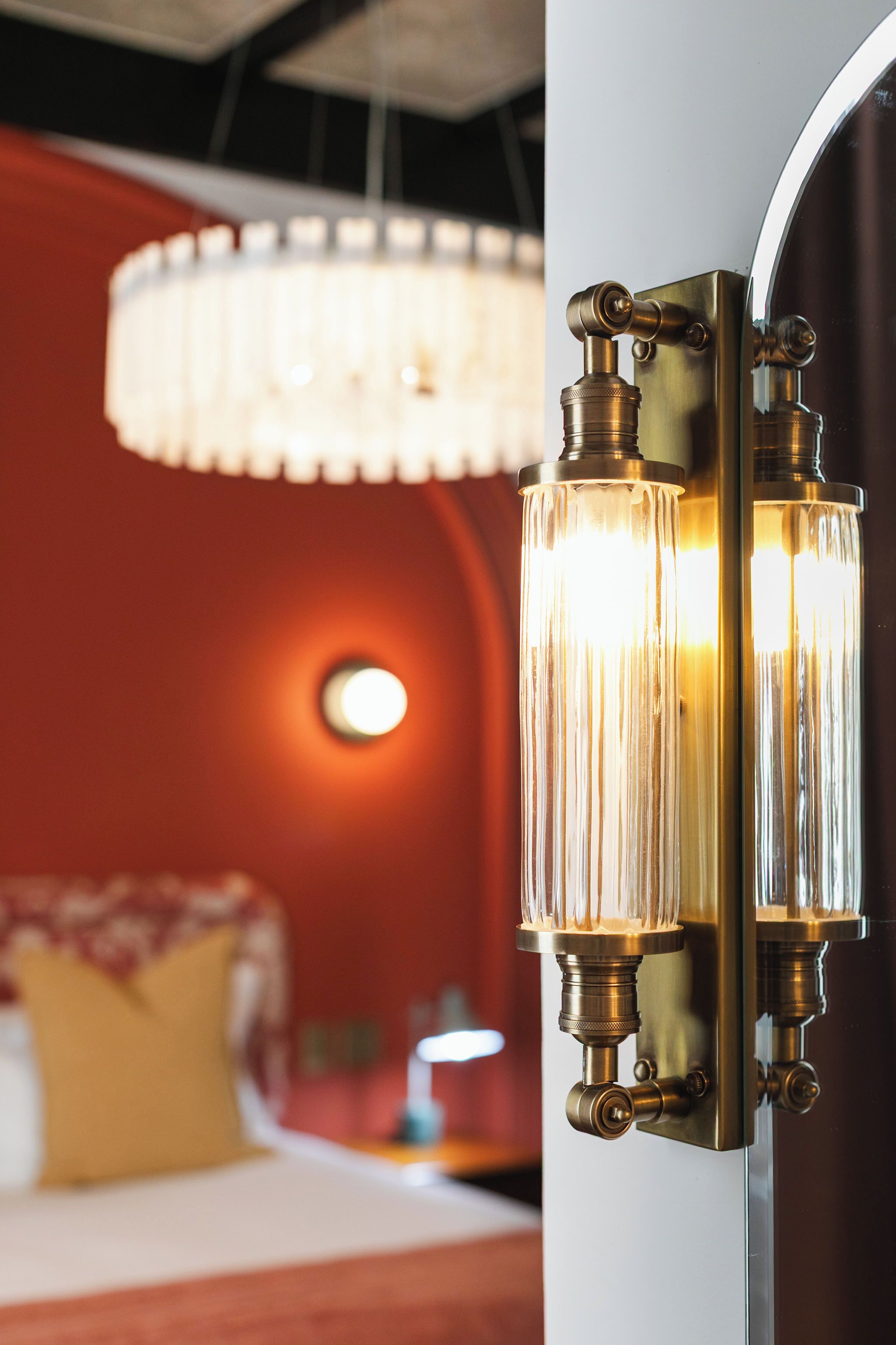 A wall-mounted light fixture with a cylindrical design and a round mirror reflection.