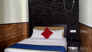Un dormitorio con cama, ventilador de techo, aire acondicionado y mesita de noche.