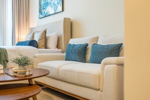 A living room with a sofa, a coffee table, and a potted plant.