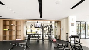 Ett modernt gym med utrustning för styrketräning, en träningsbänk och en vägg med speglar.
