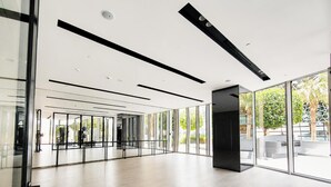 Ett rymligt interiört utrymme med stora glasfönster, en modern takdesign och ett minimalistiskt golv.