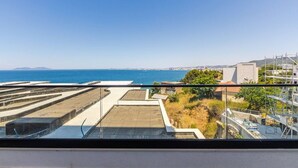 Eine Dachterrasse mit Blick auf das Meer und die ferne Stadtlandschaft.