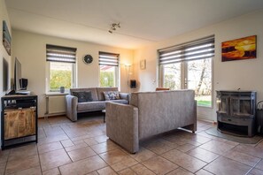 Ein Wohnzimmer mit einer Couch, einem Couchtisch, einem Fernseher und einem Kamin.