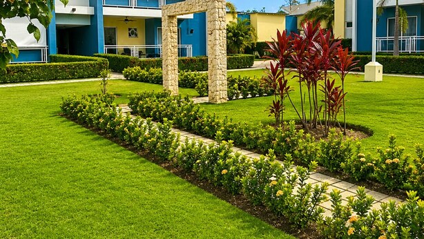 Un hotel moderno con un cortile centrale, caratterizzato da un prato curato e diverse piante.