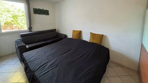 Un dormitorio con cama, sofá y ventana.