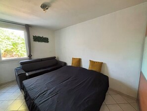 Ein Schlafzimmer mit Bett, Sofa und Fenster.