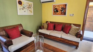 Uma sala de estar com dois sofás, uma mesa de centro e quadros nas paredes.