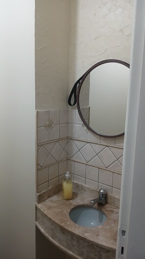Ein Badezimmer mit Waschbecken, Spiegel und Seifenspender.