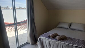 Una camera da letto con un letto, tende e vista sull'acqua.