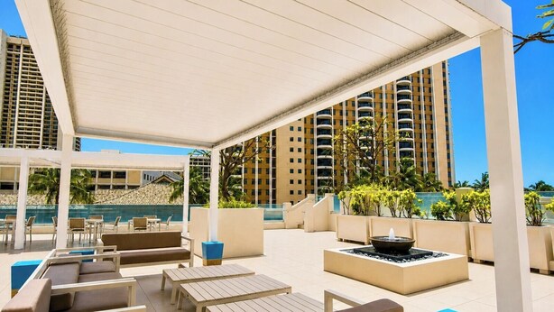 A rooftop lounge with outdoor seating, a fire pit, and a pool in the background. - Ilikai Hotel | 1-Bedroom Ocean View Suite | Car Incl. w/ 6 nights | ILK-937 by KBM (Honolulu)