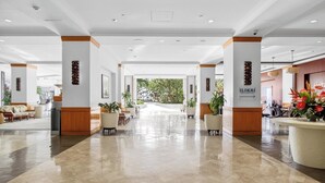 A spacious lobby with a polished floor, wooden accents, and potted plants. - Ilikai Hotel | 1-Bedroom Ocean View Suite | Car Incl. w/ 6 nights | ILK-937 by KBM (Honolulu)