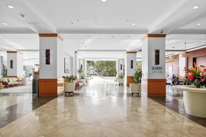 A spacious lobby with a polished floor, wooden accents, and potted plants. - Ilikai Hotel | 1-Bedroom Ocean View Suite | Car Incl. w/ 6 nights | ILK-937 by KBM (Honolulu)