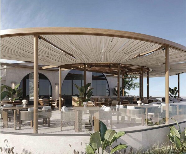 An outdoor seating area with a circular canopy, tables, chairs, and potted plants. - Marsa Boutique Hotel Marina El Alamein (El Alamein)