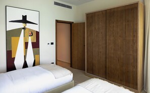 A hotel room with a bed, a wardrobe, and a painting on the wall. - Marsa Boutique Hotel Marina El Alamein (El Alamein)