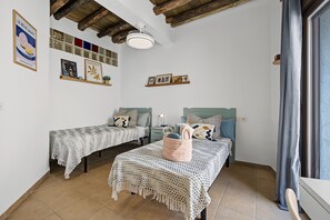 A room with two beds, a ceiling fan, and a wall with framed pictures and a sign. - Casa Rubia Limón Holiday Home (Béznar)