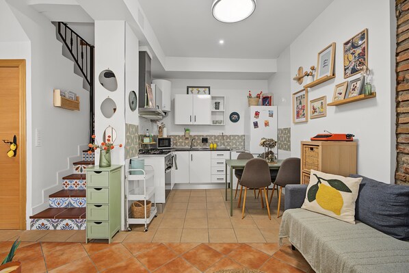 Un espace de vie compact comprenant une cuisine, un coin repas et un canapé.