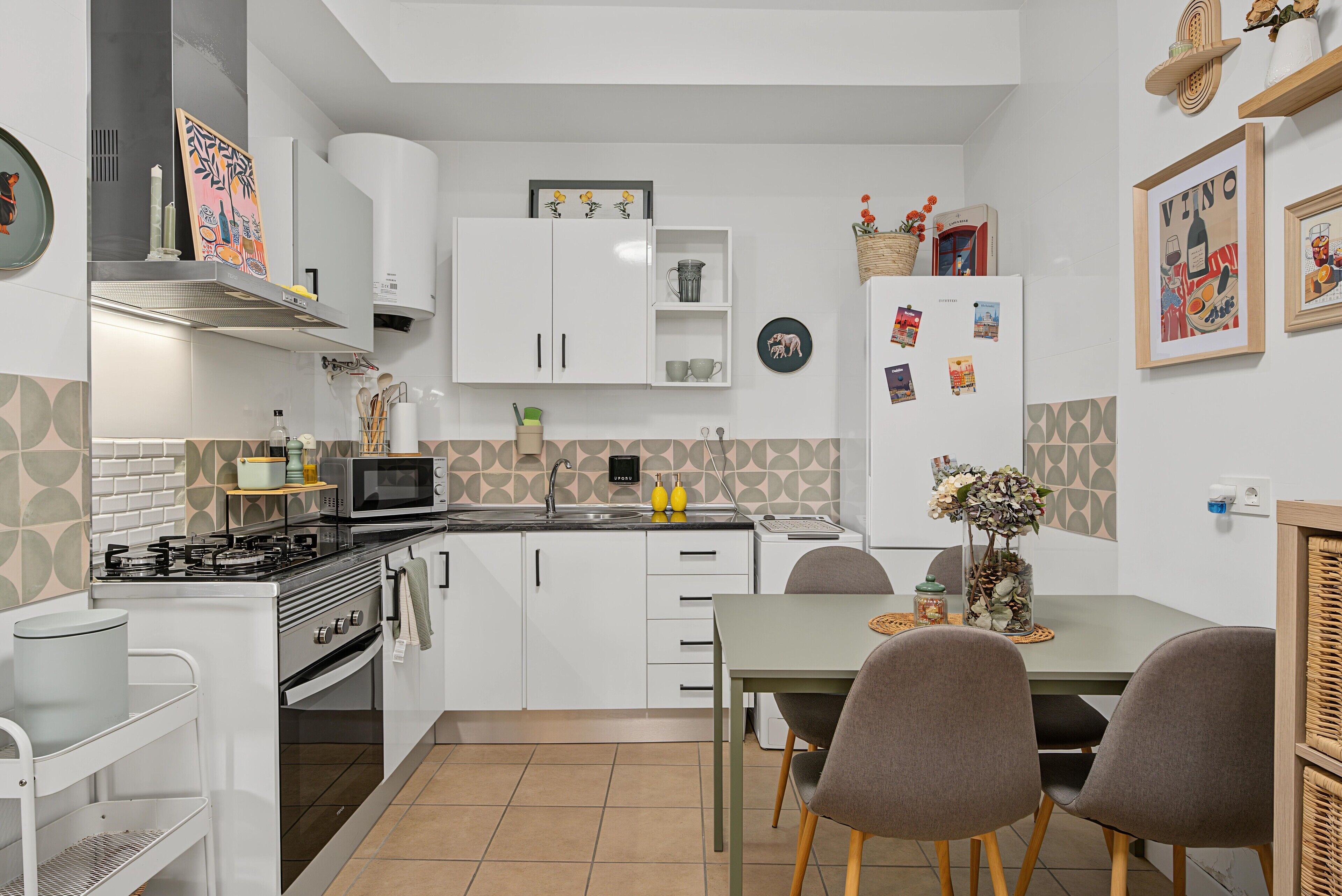 A compact kitchen with white cabinets, a microwave, a gas stove, and a dining area with a table and chairs.