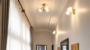 A hallway with a wooden bench, a mirror, and wall-mounted light fixtures. - Modern Vic Falls Home (Victoria Falls)