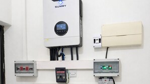 Una habitación con pared blanca, un acondicionador de aire Sumry, un panel de control y un calentador de agua.