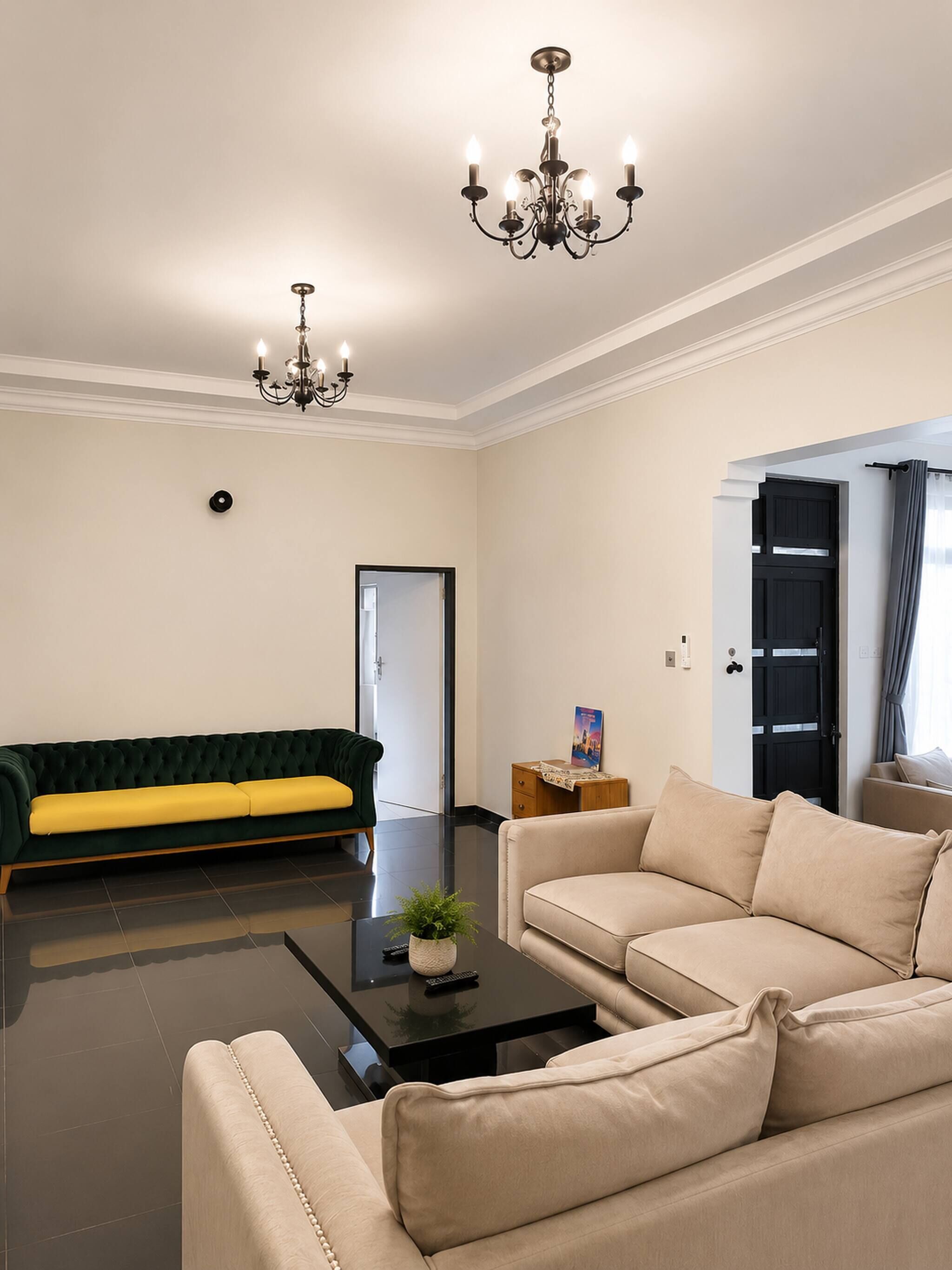 A modern living room with a green sofa, beige sofa, and a coffee table with a plant.