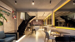 Un interior moderno con escalera, zona de estar y bar.