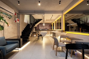 A modern interior with a staircase, seating area, and a bar. - Cyber Violet Studio @ Saigon's alley Rooftop Onsen (Thành phố Hồ Chí Minh)