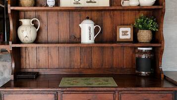 A wooden cabinet with drawers and shelves, decorated with plants and framed pictures.