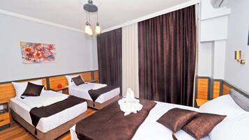 A hotel room with two beds, a ceiling fan, an air conditioning unit, a painting on the wall, and a window with curtains.
