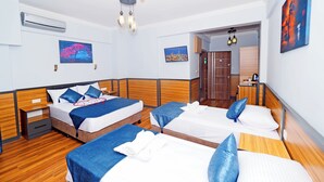 A hotel room with two beds, a wooden headboard, a ceiling fan, and artwork on the walls. - ARGES SUİTE HOTEL (istanbul)