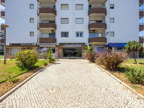 A building with a cobblestone entrance, a sign for 'Edificio Solmone,' and a clinic sign. - Solmonte Apartment - Pool Access, Beach Close (Portimão)