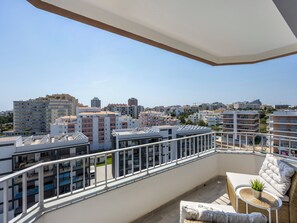 A balcony with a view of a cityscape, including various buildings and a clear sky. - Solmonte Apartment - Pool Access, Beach Close (Portimão)