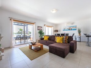 Una sala de estar moderna con un sofá, una mesa de centro y un comedor con sillas y una mesa.