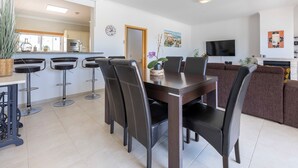 Ein modernes Wohnzimmer mit Essbereich, Fernseher und Kamin.
