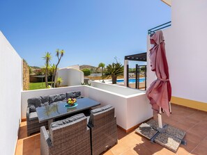 Eine Dachterrasse mit Essbereich, Pool und Blick auf die umliegende Landschaft.
