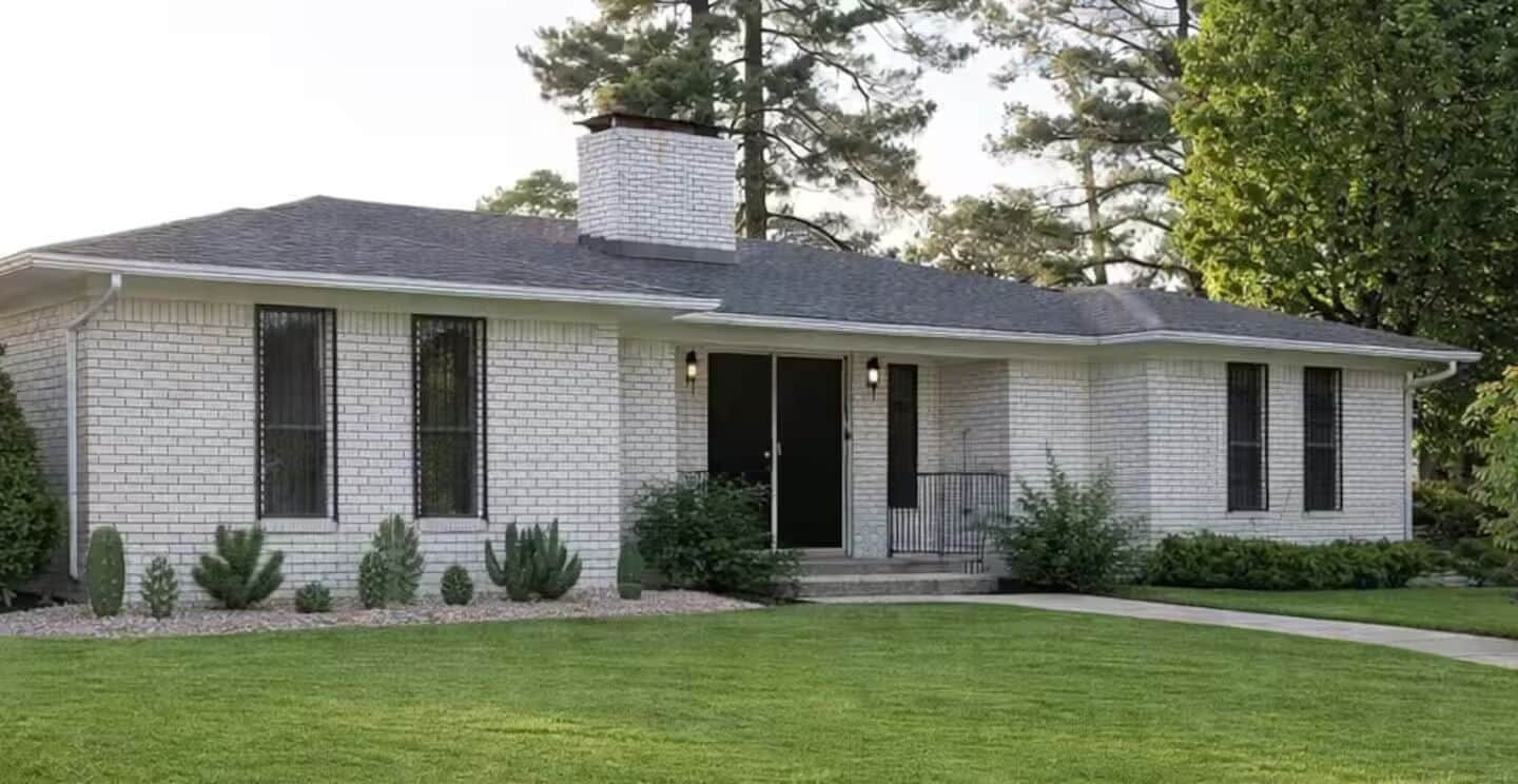 A single-story house with a brick exterior, a chimney, and a front porch.
