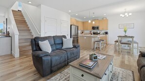 A modern apartment with a living room, kitchen, and staircase. - Page Place: Modern Extended Stay in Newberg, Dog-Friendly (Newberg)