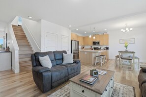 Eine moderne Wohnung mit Wohnzimmer, Küche und Treppe.