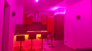 A modern interior with a bar area featuring three stools and a counter. - Luxury 3-star Apartment Rental for 6 People (Tignes)