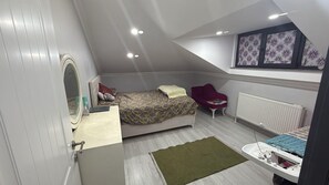 A bedroom with a bed, a chair, a radiator, and a small table with a mirror. - Cozy 2 Seprate Bedroom Apartment in Küçükçekmece With Stunning Views (Istanbul)