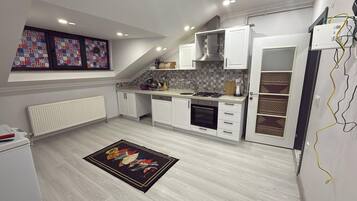 Una cocina moderna con muebles blancos, horno integrado y salpicadero de azulejos.