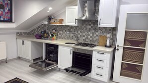 A kitchen with white cabinets, a built-in oven, a gas stove, and a patterned backsplash. - Cozy 2 Seprate Bedroom Apartment in Küçükçekmece With Stunning Views (Istanbul)