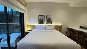 A hotel room with a bed, a desk, and a chair. There are two framed pictures on the wall. - w Enchanting Loft in the Heart of Roma Sur (Mexico City)