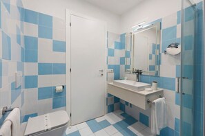 Ein Badezimmer mit Toilette, Waschbecken und Spiegel.