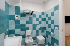 Een badkamer met een hygiëneschuimer, toilet en wastafel.