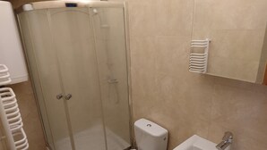 A bathroom with a glass-enclosed shower, a toilet, and a sink. - Charming studio apartment in the heart of Kraków (Kraków)
