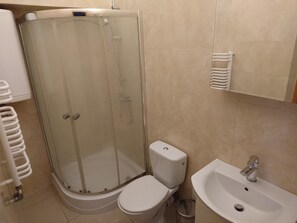 Ein Badezimmer mit Duschkabine, Toilette und Waschbecken.