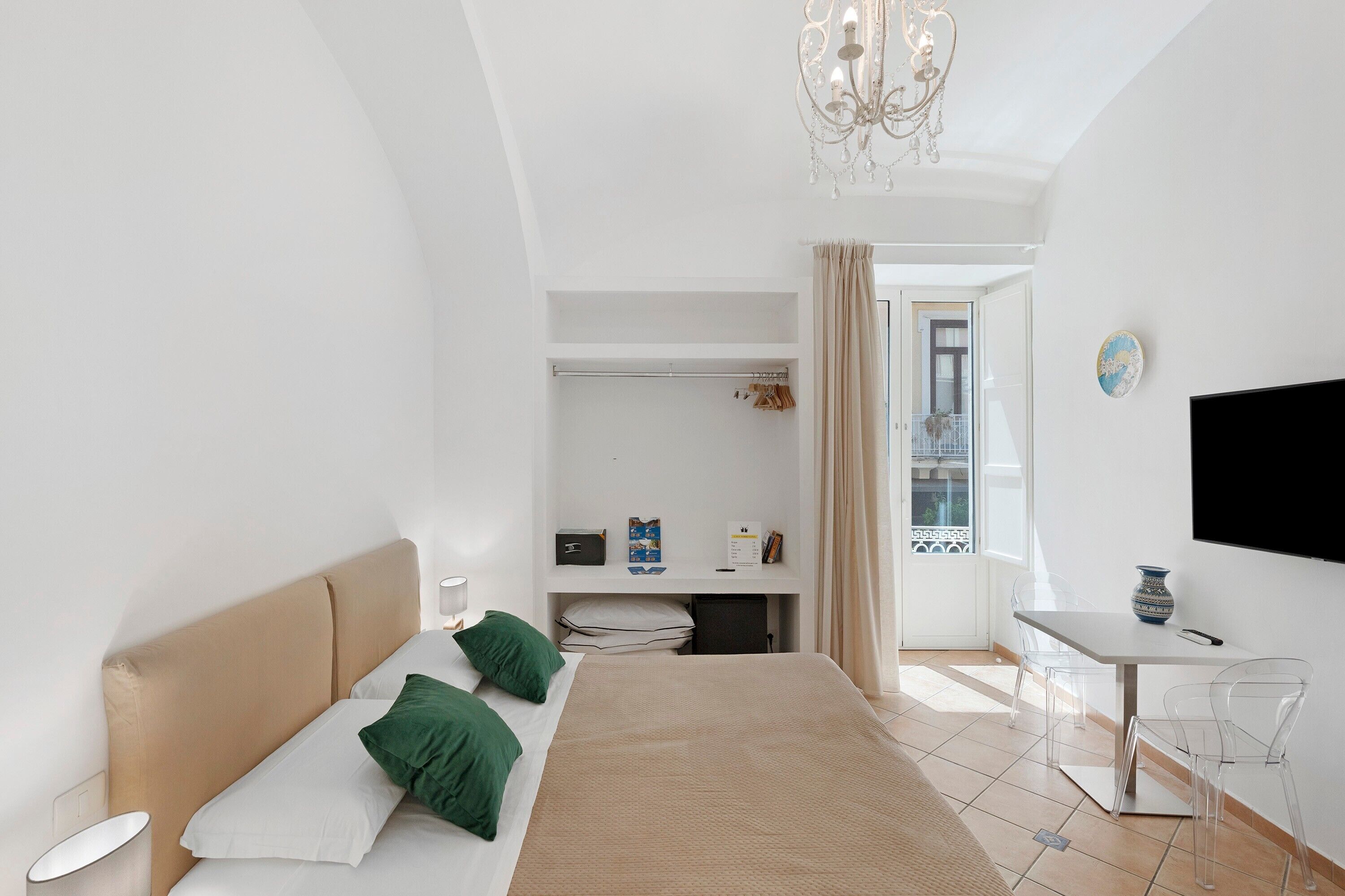 Une chambre d’hôtel moderne équipée d’un lit, d’un bureau, d’une télévision et offrant une vue sur l’extérieur.