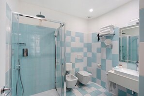 A bathroom with a glass shower enclosure, a bidet, a toilet, and a sink with a mirror. - Sorrentina Guest House – Quadruple Room with Balcony and Wi-Fi (Sorrento)